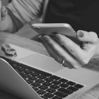 Sitting person with an laptop while using a smartphone